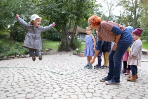 Erzieherin schwingt Seil beim Seilspringen im Kindergarten
